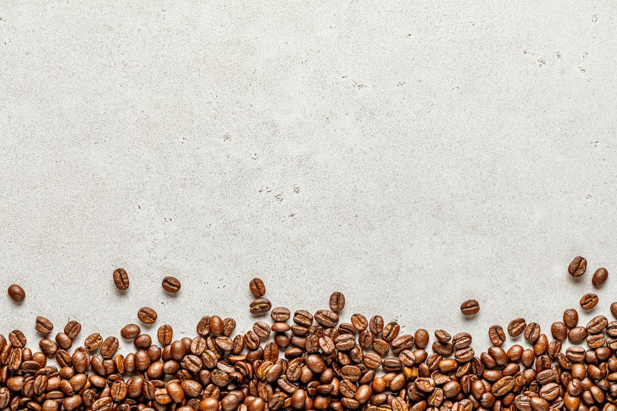 Granos de café tostados sobre una superficie clara